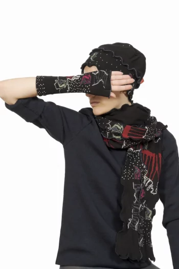 Bonnet en coton au motif de poissons colorés sur un fond noir. De la marque Berthe Aux Grands Pieds. Fabrication Française .